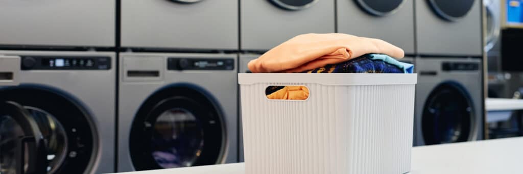 header image laundry basket with colored clothes table public laundromat