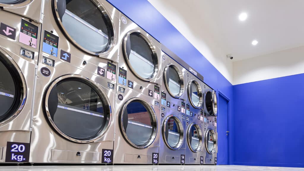 row vending washing machines clothes dryers inside modern laundromat shop